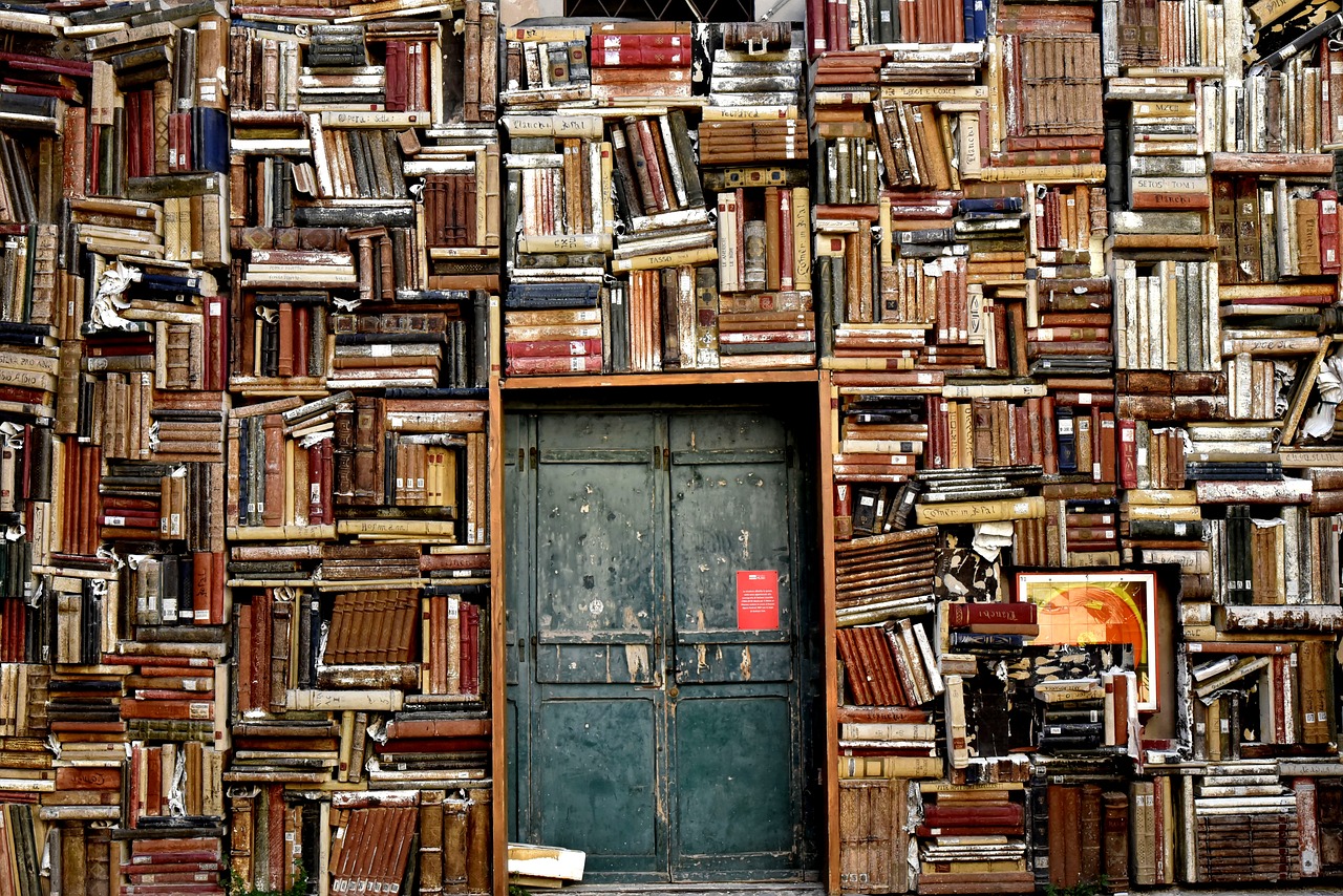 A door surrounded by shelves of books at all angles