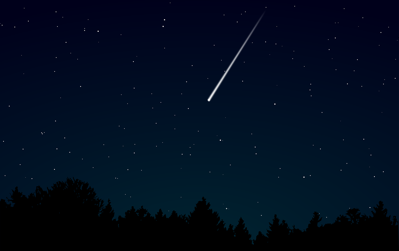 A shooting star against a black field of stars
