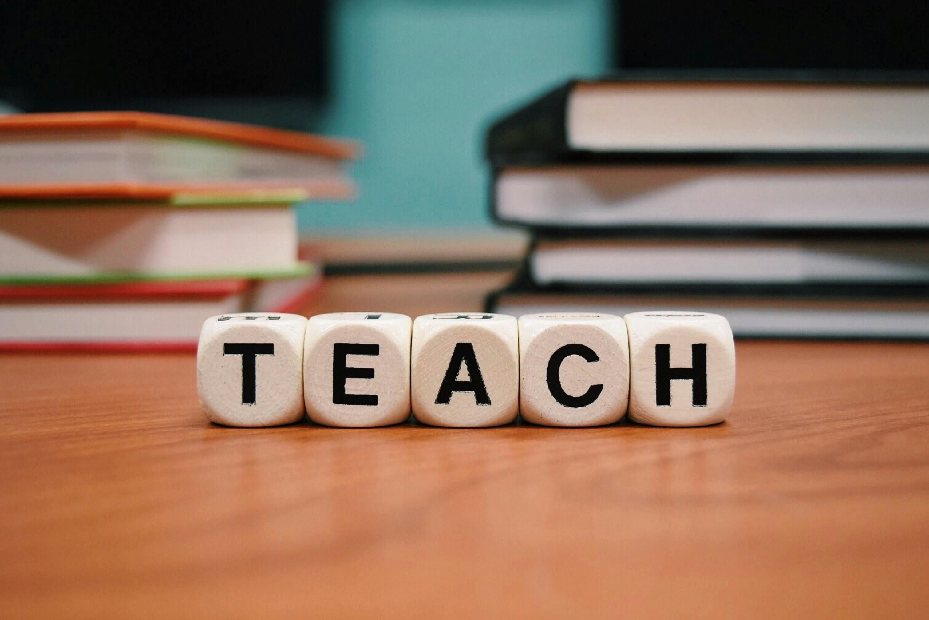 Dice spelling the word TEACH.