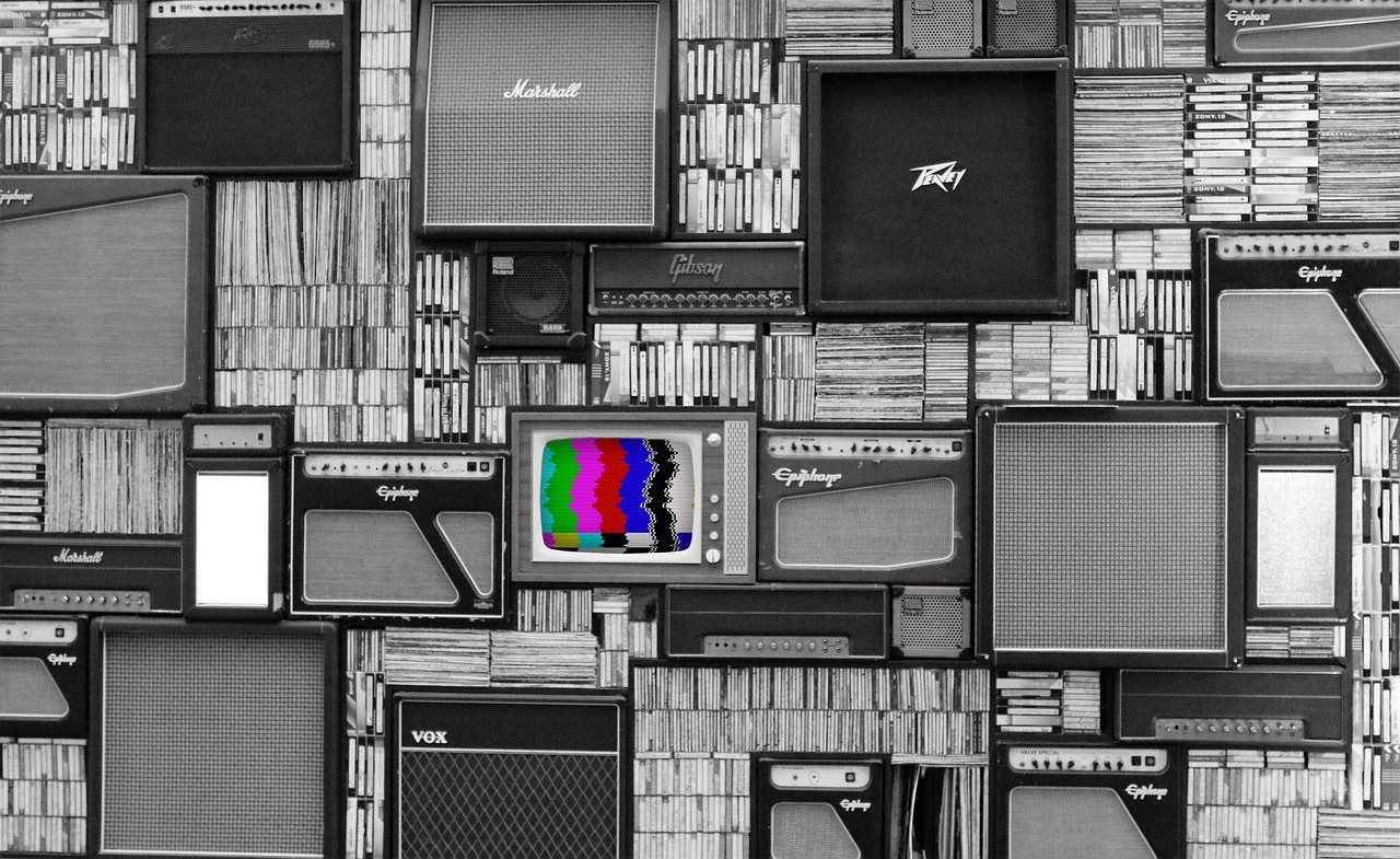 A gray wall of stereo equipment. In the middle, one burst of color: a television tuned to a dead channel